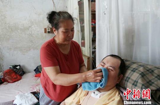 每次喂完食物后，梁青蘭都要仔細地幫兒子清理干凈?！∩忻鱾b 攝