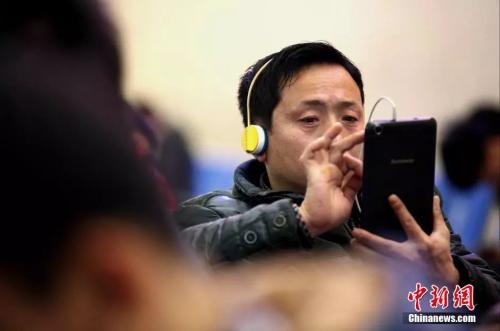 資料圖：候車室內(nèi)，玩手機(jī)的&ldquo;低頭族&rdquo;隨處可見。刷微博、聊微信、玩游戲、看電影，高科技將大多旅客變?yōu)槭謾C(jī)&ldquo;低頭族&rdquo;。<a target='_blank' ><p  align=