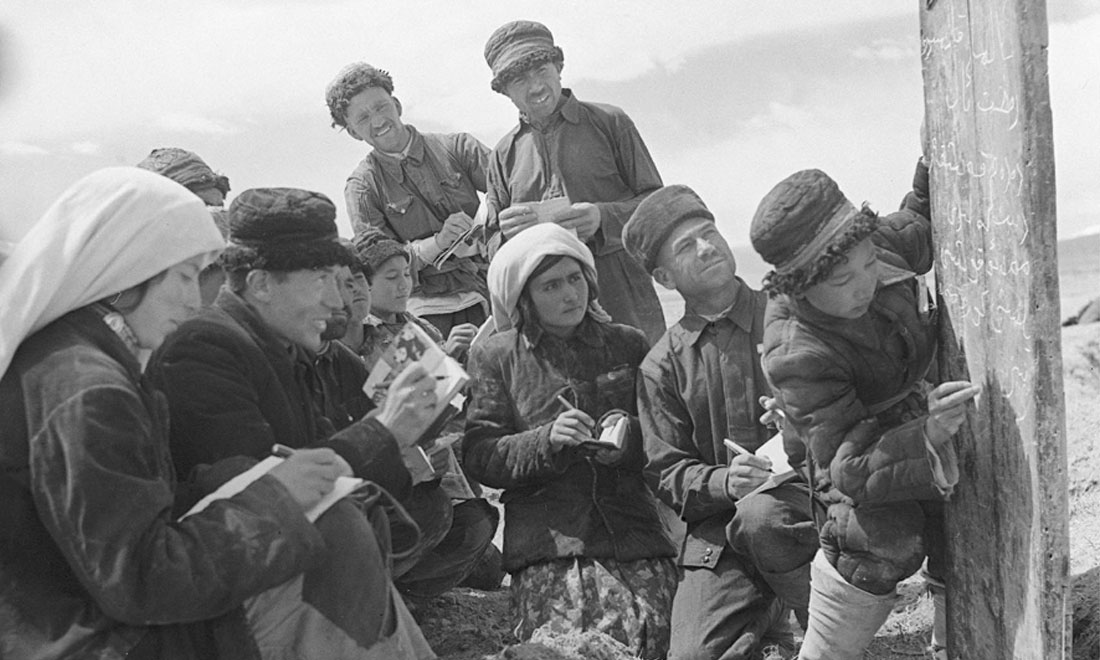 1960年6月，新疆慕士塔格峰下，大人們在小學(xué)生幫助下學(xué)習(xí)文化。新華社記者武純展攝