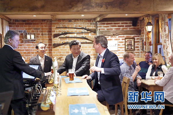 這是會晤結(jié)束后，習(xí)近平在卡梅倫陪同下乘車前往當(dāng)?shù)匦℃?zhèn)體驗酒吧文化。新華社記者 鞠鵬 攝